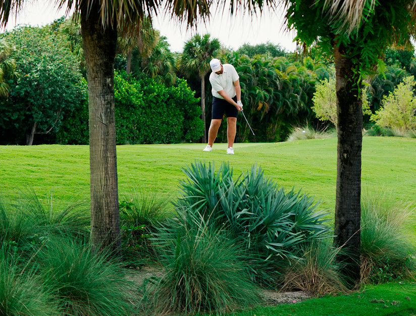 Golfer hitting ball out of rough