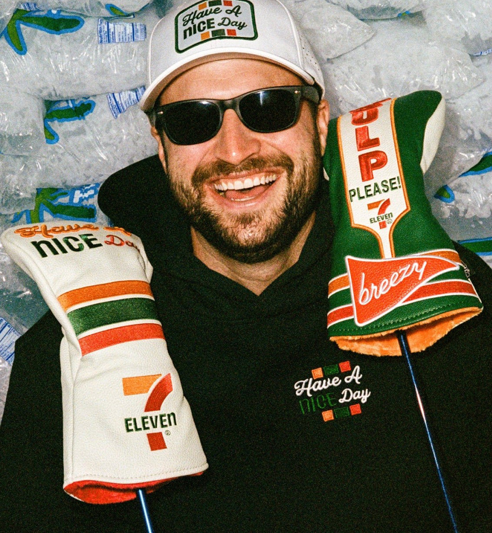 Bob holding two golf woods with special edition 7 Eleven headcovers