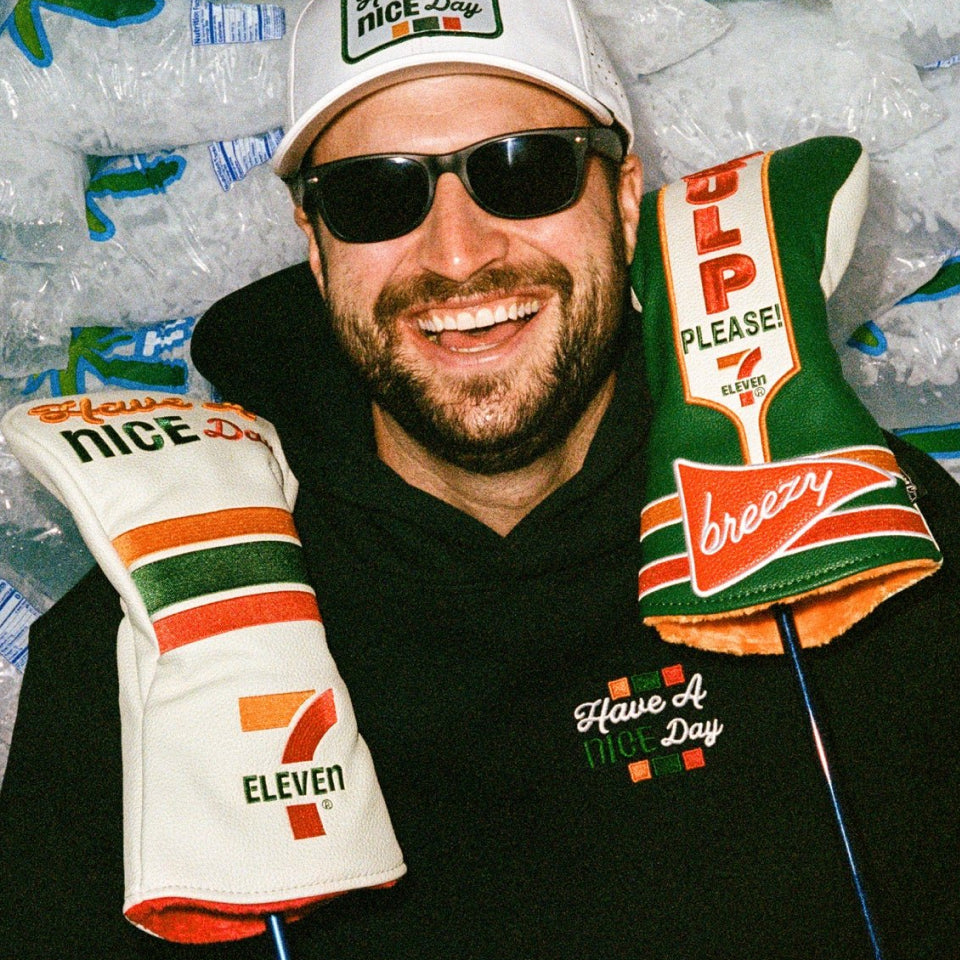 Bob holding two golf woods with special edition 7 Eleven headcovers